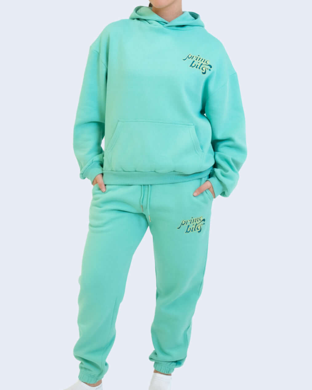 Model wearing mint green Prime Bites hoodie and jogger set featuring oversized hood and elastic waist.