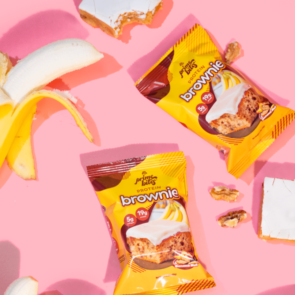 Banana Nut protein brownies with walnuts on a pink background, showcasing fuel for nutritious snacking.