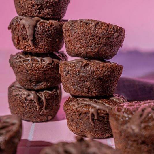 Chocolate Fudge Mini Muffins by Prime Bites stacked, rich chocolatey texture, perfect for guilt-free indulgence.