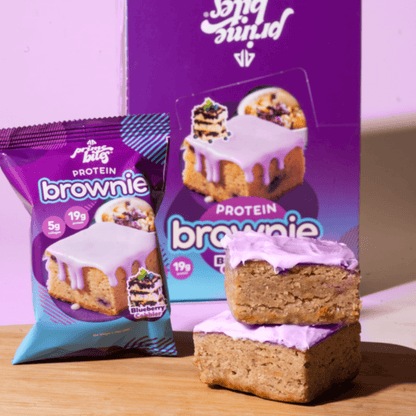 Blueberry protein brownie bites with purple frosting, showcasing a delicious and nutritious snack option.